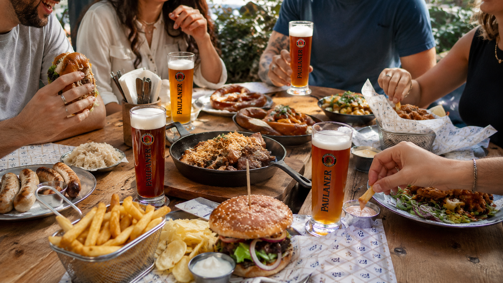 מגשי אוכל ובירה Paulaner על השולחן